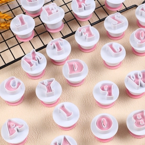 Detail shot of alphabet cookie stamp plungers on a rack for fondant cake decorating
