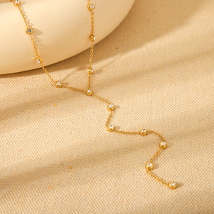Detailed macro view of 18K gold-plated stainless steel Y-necklace with small diamonds