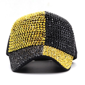 Detailed view of handmade sparkling rhinestones on black and gold baseball cap surface