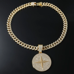 Vue détaillée du collier chaîne cubaine dorée avec pendentif disque étoile serti de cristaux
