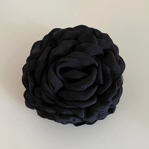 Detailed view of the layered black fabric floral hair claw clip in a rose-inspired design