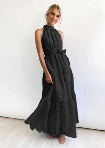 Close-up of black checkered fabric texture on sleeveless halter maxi dress with belt
