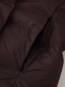 Detailed macro view of dark brown quilted puffer jacket fabric with seamless pocket stitching