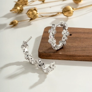 Créoles en argent avec motifs de croix et gemmes roses sur support en bois élégant