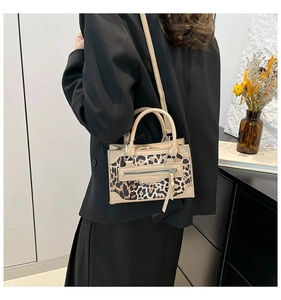 Detalle de bolso de mano patchwork de leopardo con cremallera frontal y correa de hombro