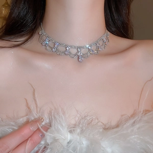Primo piano della collana con pendente a goccia d'acqua ondulata e diamanti su modella