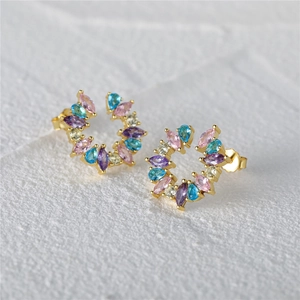 Macro shot of 925 silver stud earrings with colorful zircon stones in a gold finish