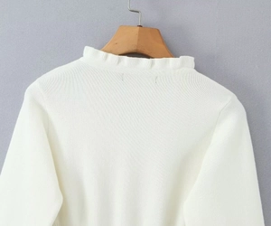 Dettaglio ravvicinato di cardigan bianco a maglia con colletto a balze rifinito