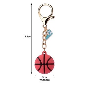Detail view of red basketball keychain with mini sneaker charm and golden chain, 9.8cm
