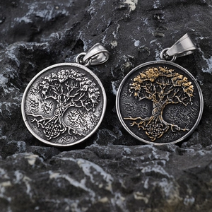 Viking Tree of Life pendants in silver and two-tone gold finish on black rock background