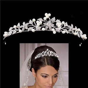 Elegant silver bridal tiara with pearls and crystal leaf motifs on black background.