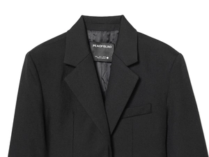 Close-up of the collar and size label of a black tailored blazer for women