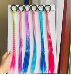 Detail of six colorful synthetic hair extensions with black elastic bands for kids
