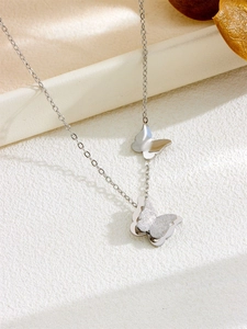 Detailed view of silver butterfly pendants with matte and polished texture finishes