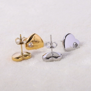 Macro shot of 12mm gold and silver polished heart stud earrings with inlaid crystal