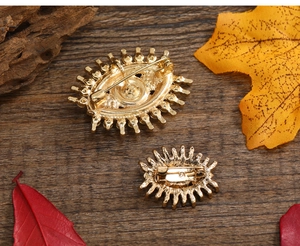 Close-up of vintage evil eye brooches with gold plating and secure safety pin back