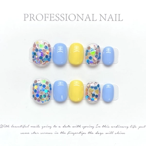 Detail of blue and yellow handmade press-on nails with holographic star glitter accents