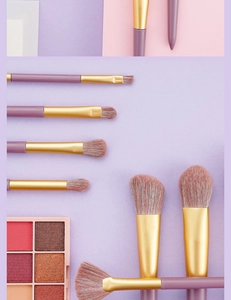 Flat lay of purple makeup brush set with golden ferrules and pink eyeshadow palette