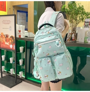 Detail of light green bear print backpack with multiple functional zipper pockets