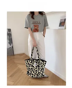 Detailed view of beige leopard print canvas tote bag paired with a casual summer outfit