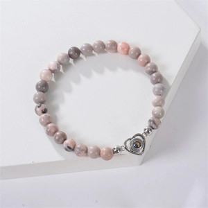 Detail shot of pink zebra stone beaded bracelet with metal heart projection pendant