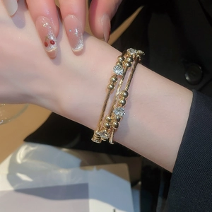 Macro shot of gold layered bracelet with sparkling zircons on a model's wrist