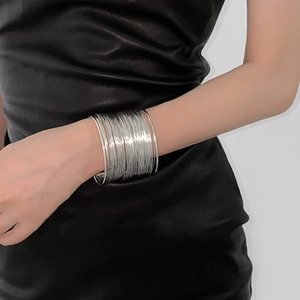 Detail of silver multi-layered wrap cuff bracelet with a polished mirror finish on arm