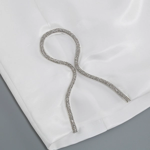 Macro shot of white satin fabric with intricate silver rhinestone trim detailing