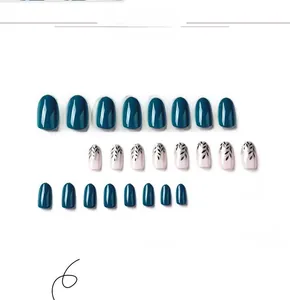 Detail view of teal blue press-on nails with silver foil and black leaf pattern
