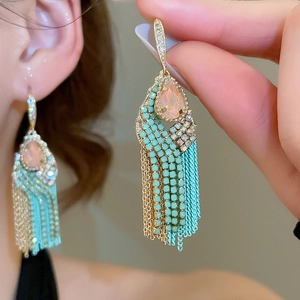 Detailed close-up of vintage tassel earrings with pink teardrop zircon and turquoise beads
