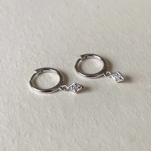 Close-up of S925 sterling silver hoop earrings featuring a diamond-set rhombus pendant