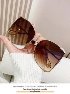 Détail de lunettes de soleil oversize dorées avec des verres marron dégradés