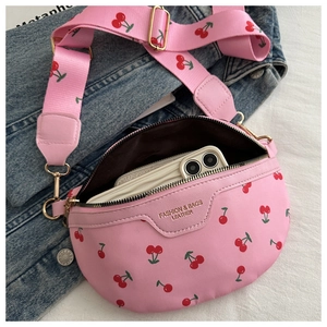 Detail of pink cherry print crossbody bag showing interior storage capacity with phone