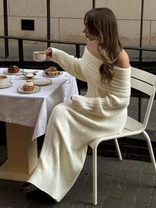 Detail of ribbed knit fabric texture on an off-shoulder cream white long dress