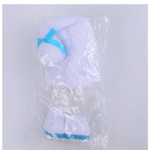 Detail of plush Christmas gnome accessory with blue bow in transparent packaging