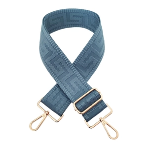 Close-up of gray-blue maze pattern adjustable bag strap with golden metal clasps