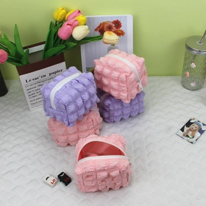Macro shot of cubic bubble textured makeup bags in pastel pink and purple colors
