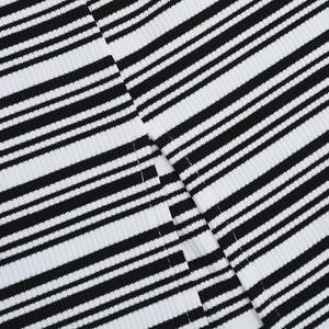 Close-up of side slit detail on black and white striped ribbed knit slim dress