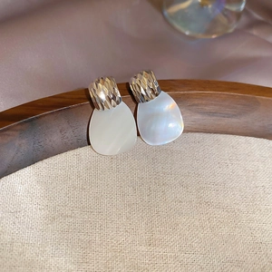 Dettaglio orecchini a cuore placcati oro 24k con madreperla e texture a diamante