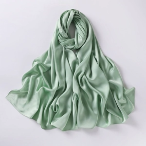 Close-up of green chiffon silk scarf showing smooth soft texture and elegant folds