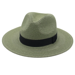 Detail of dark green Panama hat featuring fine straw weave and wide black ribbon band