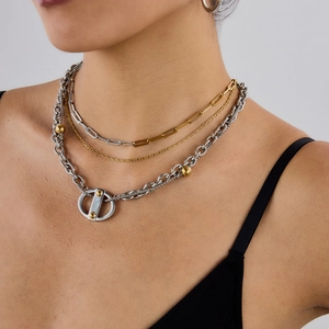 Gros plan de colliers punk multicouches en acier titane avec perles d'or et pendentifs