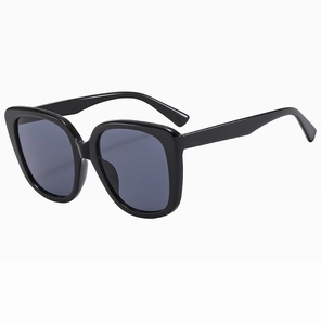 Detailed close-up of large black square sunglasses with smooth frames and dark lenses