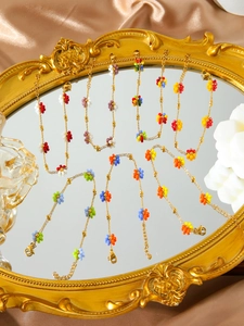 Detail view of colorful floral beaded bracelets on a golden vintage mirror tray