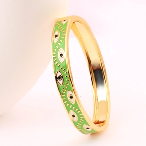 Detailed view of gold-plated Evil Eye cuff bracelet with green enamel inlay design