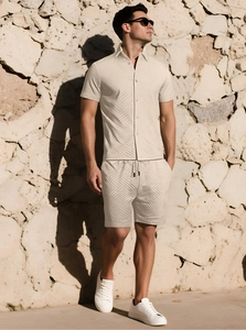 Dettaglio del completo estivo beige da uomo che mostra la trama jacquard geometrica
