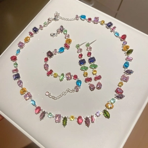 Detailed close-up of a silver jewelry set with vibrant multi-color gemstones and crystals