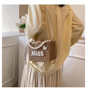 Detail of straw woven bucket bag with pearl heart, Miss lettering and pearl handle