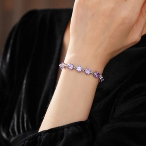 Close-up of a purple round zircon bracelet on a model wrist with silver finish