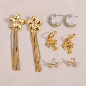 Détail de boucles d'oreilles fleur à pompon plaquées or 18K et puces cocotier